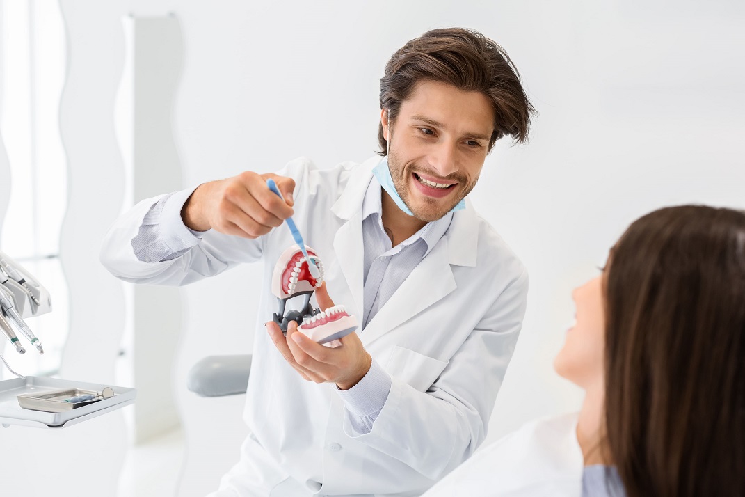 A dental professional showing proper brushing techniques